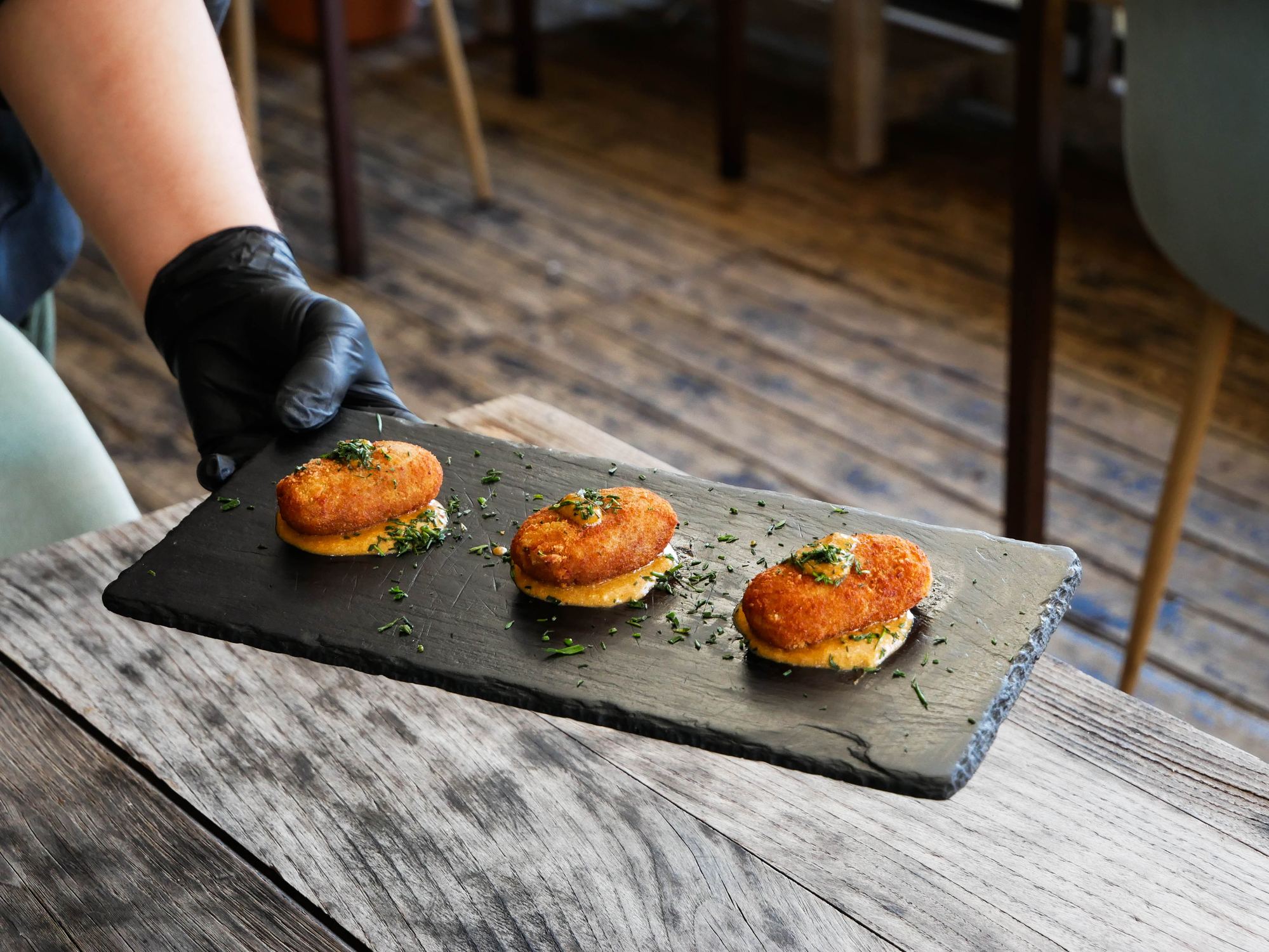 Croqueta de caña de lomo sobre salsa de ibéricos, premio a Mejor Croqueta de Sevilla en el Festival Croqueta Crush en restaurante Madreselva Tapas Sevilla