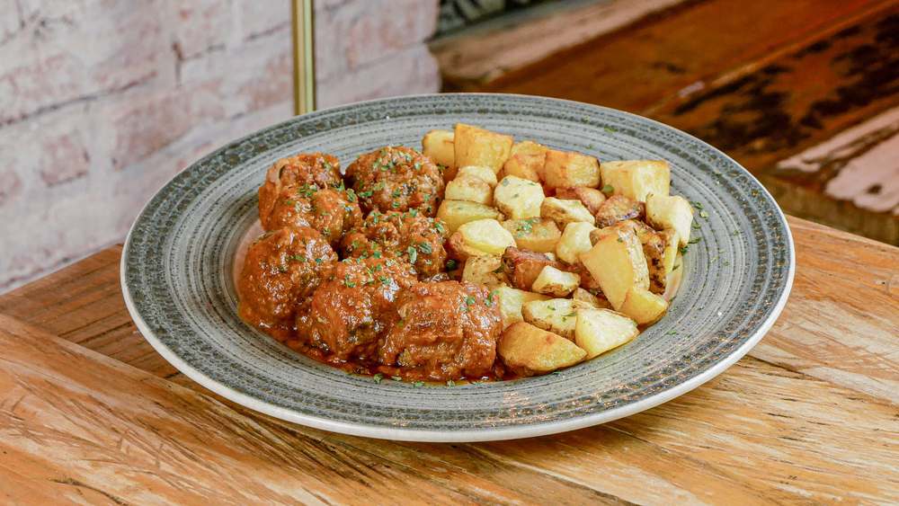 Albóndigas de merluza y choco guisadas en salsa de la abuela en restaurante Madreselva Tapas Sevilla