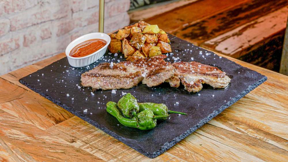 Presa con patatas y pimientos de Padrón en restaurante Madreselva Tapas Sevilla